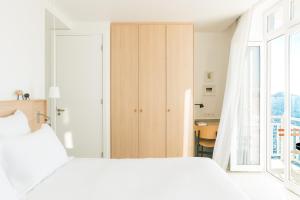 a bedroom with a white bed and a closet at Les Bords De Mer in Marseille