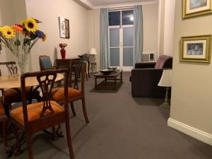 - un salon avec une table, des chaises et un canapé dans l'établissement Boutique Apartment in The Heart of Adelaide CBD, à Adélaïde