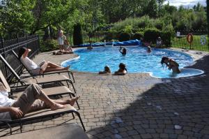 um grupo de pessoas sentadas numa piscina em Hôtel Le Francis em New Richmond