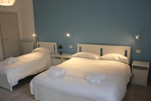 2 camas en una habitación de hotel con sábanas blancas en Roman Sunrise Rooms, en Roma