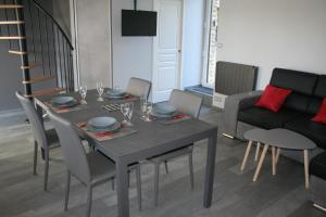 - une salle à manger avec une table, des chaises et un canapé dans l'établissement A 20 kms du Mont St Michel, Charme à la campagne, à Saint-Senier-de-Beuvron