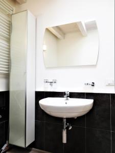 a bathroom with a sink and a mirror at Monolocale con giardino a 100m dal mare Punta Ala in Punta Ala