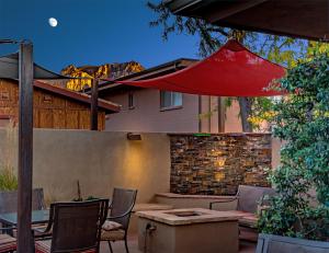 une terrasse avec une table, des chaises et un parasol dans l'établissement Sedona Uptown Suites, à Sedona