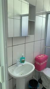 a bathroom with a white sink and a mirror at Casa, 1 quadra da praia. in Ilha Comprida +23 photos