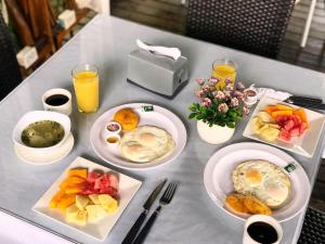 a table with plates of breakfast foods and drinks at Hotel Madreselva in Leticia