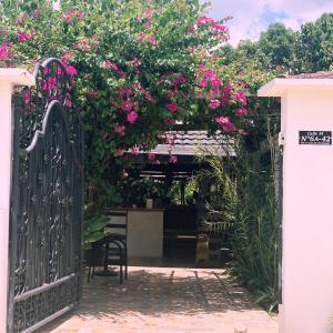 Zugang zu einem Garten mit einem Tor mit rosa Blumen in der Unterkunft Hotel Madreselva in Leticia
