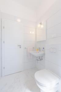 La salle de bains blanche est pourvue de toilettes et d'un lavabo. dans l'établissement Apartments Diridonda, à Omiš