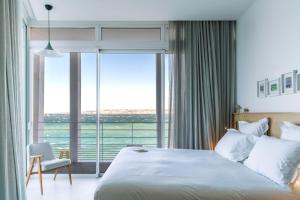 a bedroom with a large bed and a large window at Les Bords De Mer in Marseille
