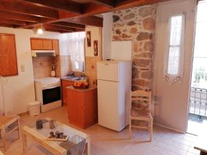 a kitchen with a refrigerator and a table at THEOS APARTMENTS in Kalymnos