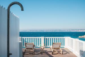a balcony with chairs and the ocean in the background at Les Bords De Mer in Marseille
