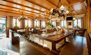 un ristorante con soffitti in legno, tavoli e sedie di Hotel Garni Bären Rüegsau a Ruegsau