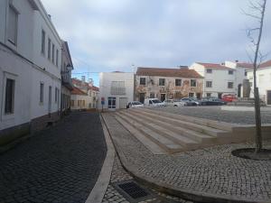 a city street with buildings and stairs in a town at Casa da Gena in Nazaré