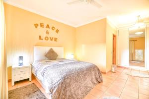a bedroom with a bed with a peace and love sign on the wall at Orange Tree Villa in Alvor in Alvor