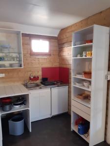 eine kleine Küche mit weißen Schränken und einer roten Insel in der Unterkunft Logement à la ferme in Hangest-en-Santerre