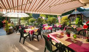 un ristorante con tavoli e sedie con tovaglie rosa di Hotel Garni Bären Rüegsau a Ruegsau Altre 16 foto