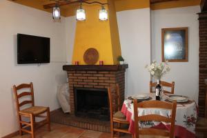 uma sala de jantar com uma mesa e uma lareira em Apartamento Rurales Rosendo: La Zajareña em Capileira
