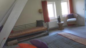uma sala de estar com um banco e uma cadeira em Het Takketiele Huis em Lochristi