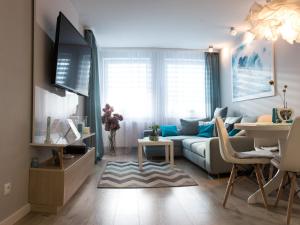salon z kanapą i stołem w obiekcie Apartament FALA-Miodowy Dom w Kołobrzegu