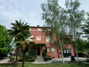 una casa rossa con alberi di fronte di B&B Maison Parco Del Brenta a Curtarolo