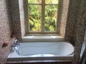 y baño con bañera y ventana. en Villa del Cigno, en Lecco