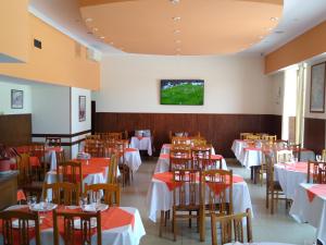 a dining room with tables and a tv on the wall at Hotel Bender in Coronel Suárez