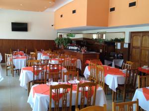 Coronel Suárez的住宿－Hotel Bender，餐厅设有桌椅,配有红色和白色的桌布