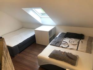 a small bedroom with two beds and a skylight at guest apartment niederalfingen in Hüttlingen