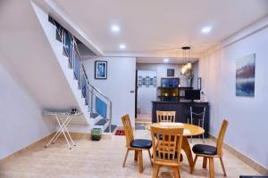 a living room with a table and chairs and a staircase at พี่จ๋า เฮ้าส์ P'Ja House in Ban Kohong