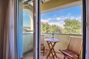 a glass door leading to a balcony with a table and a window at Apartments Gilly 2 in Premantura