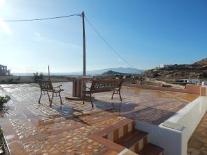 two benches sitting on top of a patio at Armonia Studios, Apartments & Villa in Mikri Vigla