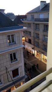 a view of a building with people sitting in a courtyard at Hotel Les Arcades in Rouen