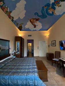een slaapkamer met een bed met een schilderij aan het plafond bij Vogue Hotel Arezzo in Arezzo