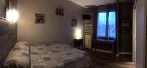 a bedroom with a bed and a window at Hotel Bernieres in Caen