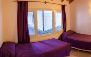 a room with two beds and a window at Rukalhue in San Martín de los Andes