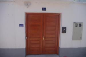 una puerta de madera en un edificio con dos letreros en Villa M, en Mostar