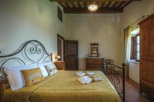 een slaapkamer met een groot bed en handdoeken bij Agriturismo Cerreto in Pienza
