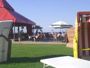 a group of people sitting at a table in a yard at Villa Hebel in Cuxhaven