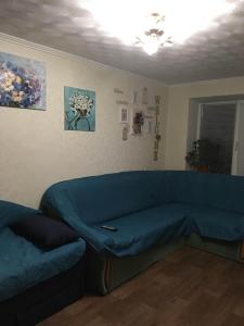 uma sala de estar com um sofá azul num quarto em Затишна двокімнатна квартира em Vatutine