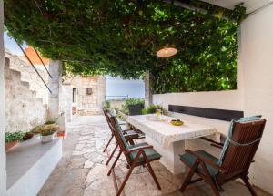 una mesa y sillas en un patio con plantas en Holiday Home Burba en Komiža