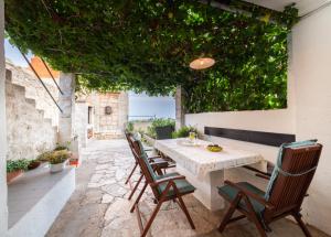 a table and chairs on a patio with plants at Holiday Home Burba in Komiža