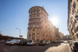 Laura luxury apartment in the center Rome في روما: مبنى طويل وبه سيارات متوقفة أمامه