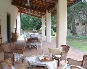 Un patio con una mesa y sillas en un patio. en Villa Montignoso, en Castagno