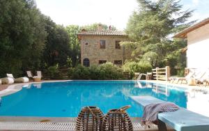 una piscina con dos sillas y una casa en Villa Montignoso, en Castagno