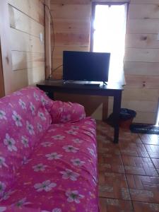 a bedroom with a couch and a desk with a laptop at Cabañas Paraiso tziscao in Comitán