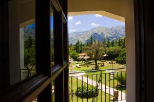 uma janela com vista para um parque e para as montanhas em El Cortijo Apart - Hotel em Merlo