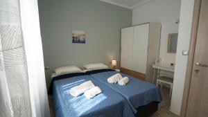 カルパトスにあるMagic View Apartment-Karpathos Port Pigadiaのベッドルーム1室(ブルーベッド1台、タオル付)