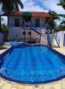 a villa with a swimming pool in front of a house at HOTELARE Hotel Brunello in Paraty