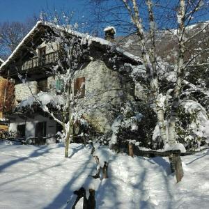 a house with snow covered trees in front of it at La Mianda in Ceres