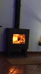 a black stove with a fire in a room at Casa Rural Tita Sacramento in Hornachos