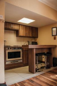 a kitchen with wooden cabinets and a stove top oven at Best Western Cumbres Inn Cd. Cuauhtemoc in Cuauhtémoc